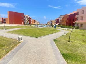 a walkway through a park with buildings and grass at Porto Matrouh unique Chalet in Marsa Matruh