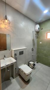 La salle de bains est pourvue de toilettes et d'un lavabo. dans l'établissement Amrutiya Farmview Suit, à Bhuj