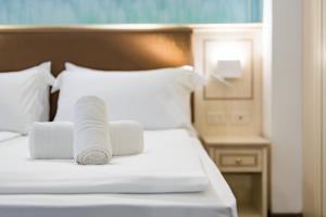 een bed met twee opgerolde handdoeken erop bij Hotel Sogno del Benaco in Limone sul Garda