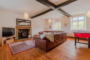 a living room with a couch and a pool table at Canons Court Lodge in Wotton-under-Edge