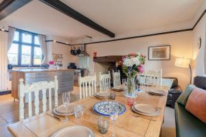 ein Esszimmer mit einem Holztisch mit Blumen darauf in der Unterkunft Canons Court Lodge in Wotton under Edge