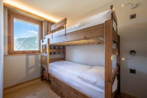 Cette chambre dispose de lits superposés, de 2 lits superposés et d'une fenêtre. dans l'établissement SWISSPEAK Resorts Vercorin, à Vercorin