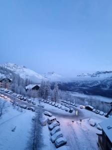 a parking lot covered in snow with cars parked at PUY SAINT VINCENT APPARTEMENT T2 BALCON SUPER PANORAMA AVEC PARKING PRIVE COUVERT et PISCINE L'ETE in Puy-Saint-Vincent +51 photos