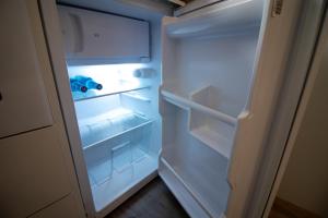 un réfrigérateur vide avec une porte ouverte dans une pièce dans l'établissement Apartamento moderno en el centro de Granada - Mititilla, à Grenade