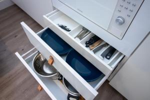 - un tiroir de cuisine blanc avec des assiettes et des ustensiles bleus dans l'établissement Apartamento moderno en el centro de Granada - Mititilla, à Grenade