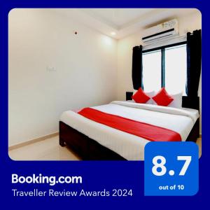 um quarto de hotel com uma cama com almofadas vermelhas em White House Regency em Sakardarā