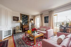 a living room with a couch and a table at Veeve - A Study in Pink in Boulogne-Billancourt