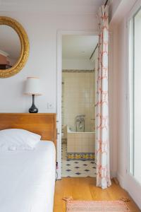 a bedroom with a bed and a bathroom with a tub at Veeve - A Study in Pink in Boulogne-Billancourt +16 photos