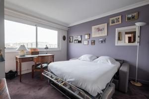 a bedroom with a bed and a desk and a window at Veeve - A Study in Pink in Boulogne-Billancourt