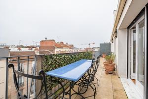 a balcony with a blue table and chairs at Veeve - A Study in Pink in Boulogne-Billancourt