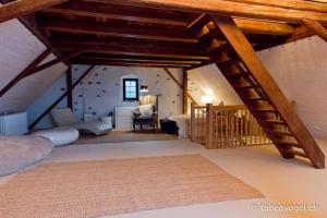 リュシュリコンにあるLuxury 250 yr old Swiss farm with wine cellarの階段付きの屋根裏部屋、ベッドルーム1室が備わります。