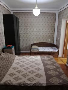 1 dormitorio con cama y banco. en markaz 6 Uy-122A Honadon-9, en Tashkent