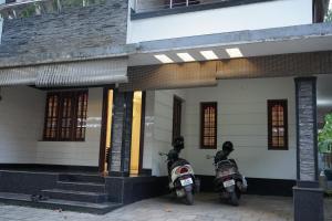 dos motocicletas estacionadas frente a un edificio en OHO ROOMS, en Ernakulam