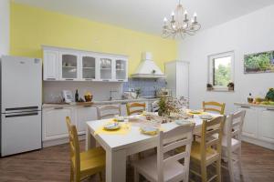 cocina con mesa blanca y nevera blanca en Villa Limone by Istrialux, en Šivati