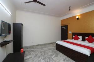 um quarto de hotel com uma cama e uma televisão de ecrã plano em Collection O Delta Square em Gurgaon