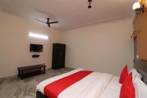 um quarto com uma cama e uma televisão na parede em Collection O Delta Square em Gurgaon