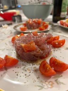 un morceau de viande avec des tomates sur une plaque dans l'établissement Villa Gelsomino Exclusive House, à Santa Margherita Ligure