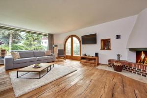 Villa Bruni في غارميش - بارتنكيرشين: غرفة معيشة مع أريكة ومدفأة
