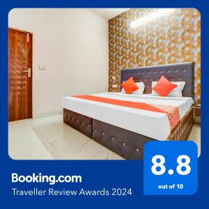 sypialnia z łóżkiem z pomarańczowymi poduszkami w obiekcie Flagship Hotel 3k Inn w mieście Ludhiana