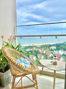 a rattan chair and a table on a balcony at Phạm Hiếu's Homestay - The Song Apartment in Vung Tau