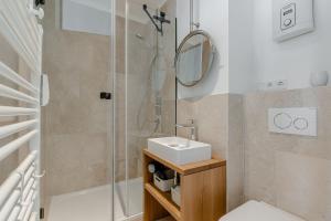 a bathroom with a shower and a sink and a mirror at App Nordseeperle in List
