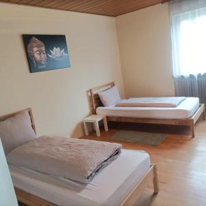 a room with two beds and a picture on the wall at Ferienunterkunft&Monteure C.C in Schwabach