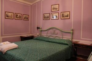 a bedroom with a bed with a green comforter at Locanda Laudomia in Manciano