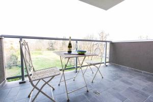 a table and chairs on a balcony with a bottle of wine at Bertelli 4 in San Lazzaro di Savena