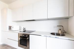 a kitchen with white cabinets and a sink at Bertelli 4 in San Lazzaro di Savena