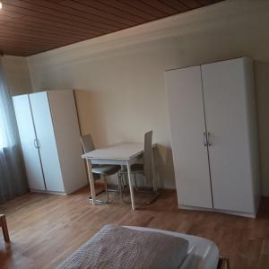 Habitación con mesa, armarios y cama. en Ferienunterkunft&Monteure C.C, en Schwabach