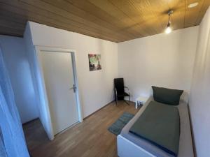 Habitación con cama y puerta con silla en Ferienunterkunft&Monteure C.C, en Schwabach