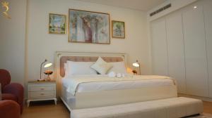 a bedroom with a large white bed with two lamps at Luxuria 2BR Soul Beach Mamsha Al saadiyat in Abu Dhabi