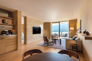 a living room with a table and chairs and a television at Conrad Hangzhou Tonglu in Yinzhu