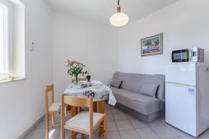 a living room with a table and a couch at Apartman Mirna in Sumartin