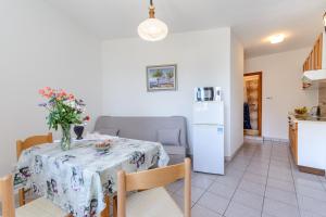 a kitchen and a table with a vase of flowers on it at Apartman Mirna in Sumartin
