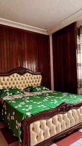 a bedroom with a bed with a green comforter at Kc luxury in Yaoundé