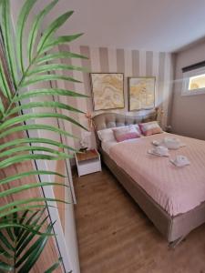una camera con un letto e una grande pianta di Luxury Apartment fronte piscina Mareverde A&V Costa Adeje ad Adeje