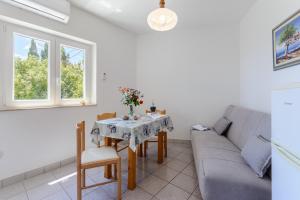 a living room with a couch and a table at Apartman Mirna in Sumartin +4 photos