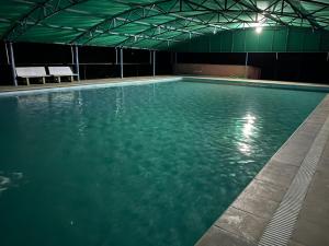 una piscina vacía por la noche en Amrutiya Farmview Suit, en Bhuj