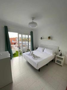 sypialnia z łóżkiem i dużym oknem w obiekcie El Olivar Caleta Mar w mieście Caleta De Fuste
