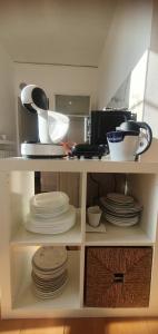 a kitchen with plates and dishes on a shelf at Ice Alley Home Città Alta in Bergamo +22 photos