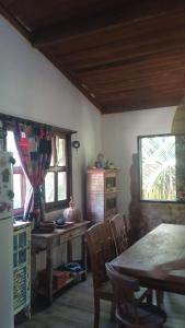 a dining room with a table and a table and chairs at Loft Jardim Imbassai in Imbassai