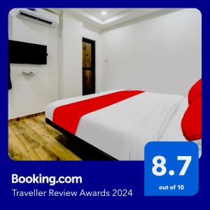 1 dormitorio con 1 cama con manta roja y blanca en Super OYO Flagship Hotel White Villa, en Dhantoli