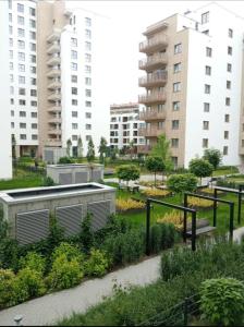 einen Garten in einer Stadt mit hohen Gebäuden in der Unterkunft Apartamenty Bokserska in Warschau