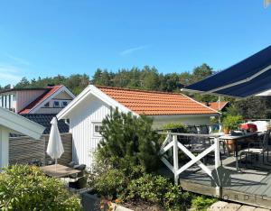 un petit hangar blanc avec une table et une terrasse dans l'établissement Modern and cozy cottage near beautiful Fjallbacka, à Fjällbacka