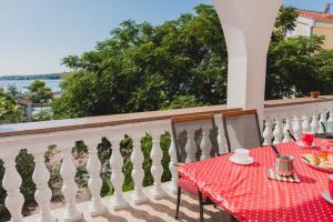 a table and chairs on a balcony with a view of the water at Villa Nike in Vodice
