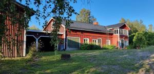 a large red barn with a yard in front of it at Villa Söder in Ojakkala