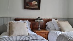 um quarto com duas camas e um candeeiro sobre uma mesa em Villa Söder em Ojakkala