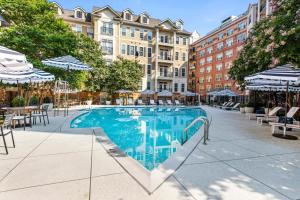 a swimming pool with tables chairs and umbrellas at North Bethesda 1br w wd pool gym nr metro WDC-608 in North Bethesda