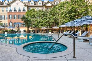a swimming pool with chairs and an umbrella at North Bethesda 1br w wd pool gym nr metro WDC-608 in North Bethesda